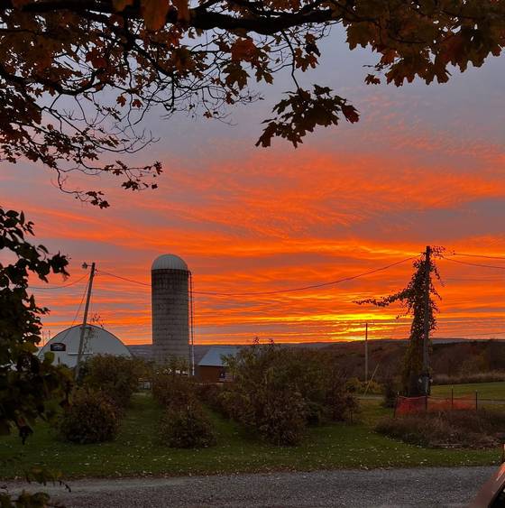 A blazing orange sunset behind the silo